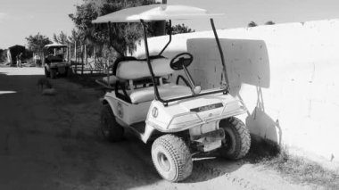 Golf cart buggy cars carts taxi on muddy sandy street road in the village and at the beach on Holbox island Mexico.