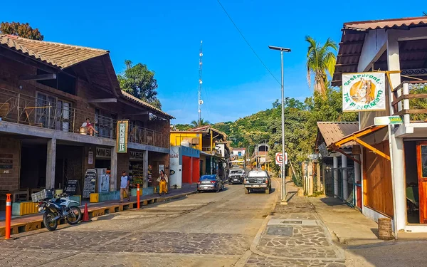Idyllic street with houses people cars and hotels stores in Mazunte Oaxaca Mexico.