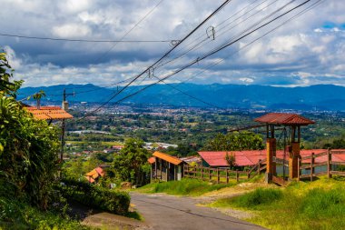 Orman ağaçları, bulutlar ve Orta Amerika 'da San Jose ve Heredia Kosta Rika' nın doğası olan güzel dağ manzarası ve şehir manzarası..
