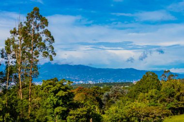 Orman ağaçları, bulutlar ve Orta Amerika 'da San Jose ve Heredia Kosta Rika' nın doğası olan güzel dağ manzarası ve şehir manzarası..