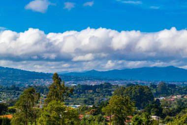 Orman ağaçları, bulutlar ve Orta Amerika 'da San Jose ve Heredia Kosta Rika' nın doğası olan güzel dağ manzarası ve şehir manzarası..