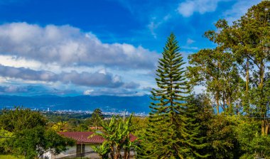 Orman ağaçları, bulutlar ve Orta Amerika 'da San Jose ve Heredia Kosta Rika' nın doğası olan güzel dağ manzarası ve şehir manzarası..