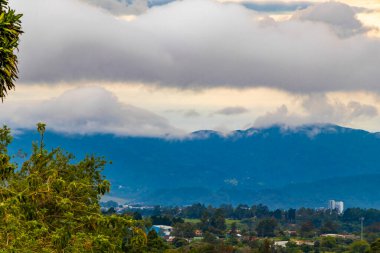 Orman ağaçları, bulutlar ve Orta Amerika 'da San Jose ve Heredia Kosta Rika' nın doğası olan güzel dağ manzarası ve şehir manzarası..
