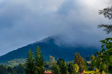 Orman ağaçları, bulutlar ve Orta Amerika 'da San Jose ve Heredia Kosta Rika' nın doğası olan güzel dağ manzarası ve şehir manzarası..