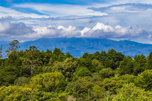 Orman ağaçları, bulutlar ve Orta Amerika 'da San Jose ve Heredia Kosta Rika' nın doğası olan güzel dağ manzarası ve şehir manzarası..