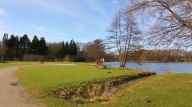 Natural beautiful panorama view with lake river fountain walking pathway and green plants trees in the forest of Speckenbtteler Park in Lehe Bremerhaven Germany.