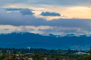 Orman ağaçları, bulutlar ve Orta Amerika 'da San Jose ve Heredia Kosta Rika' nın doğası olan güzel dağ manzarası ve şehir manzarası..