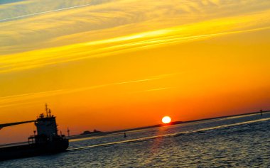 Beautiful colorful golden sunset on the North Sea coast seen from Bremerhaven over to Nordenham in Center Central North Bremerhaven Bremen Germany.