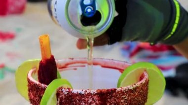 Playa del Carmen Quintana Roo Mexico 30. October 2021 Making mexican style beer with chili and lime clamato on beach in Playa del Carmen Quintana Roo Mexico.