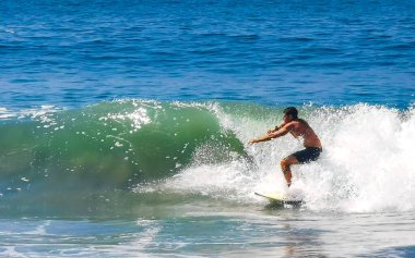 Surfer surfing on surfboard on high waves in Zicatela Puerto Escondido Oaxaca Mexico.