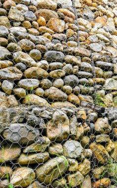 Stones rocks pinned behind a net in Zicatela Puerto Escondido Oaxaca Mexico.