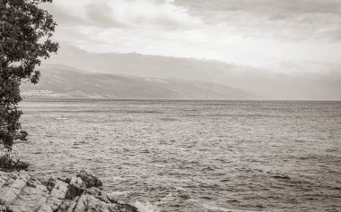 Novi Vinodolski Hırvatistan 'da muhteşem turkuaz ve kayalık plaj ve gezinti güvertesi.