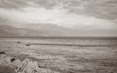 Novi Vinodolski Hırvatistan 'da muhteşem turkuaz ve kayalık plaj ve gezinti güvertesi.