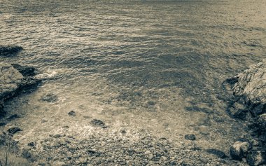 Novi Vinodolski Hırvatistan 'da muhteşem turkuaz ve kayalık plaj ve gezinti güvertesi.