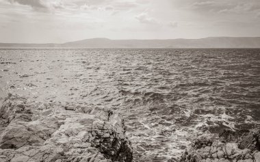 Novi Vinodolski Hırvatistan 'da muhteşem turkuaz ve kayalık plaj ve gezinti güvertesi.