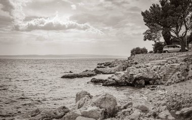 Novi Vinodolski Hırvatistan 'da muhteşem turkuaz ve kayalık plaj ve gezinti güvertesi.