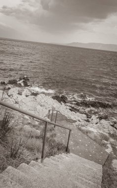 Novi Vinodolski Hırvatistan 'daki cennet turkuaz plajına ve gezinti güvertesine merdivenler.