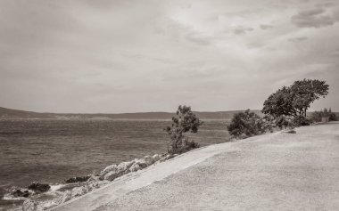 Novi Vinodolski Hırvatistan 'da muhteşem turkuaz ve kayalık plaj ve gezinti güvertesi.