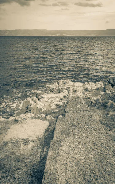 Novi Vinodolski Hırvatistan 'da muhteşem turkuaz ve kayalık plaj ve gezinti güvertesi.