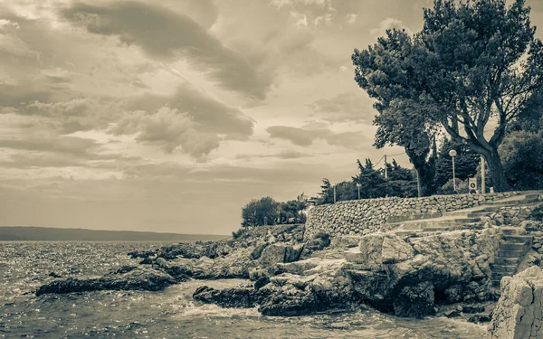 Novi Vinodolski Hırvatistan 'da muhteşem turkuaz ve kayalık plaj ve gezinti güvertesi.