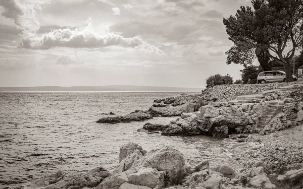 Novi Vinodolski Hırvatistan 'da muhteşem turkuaz ve kayalık plaj ve gezinti güvertesi.