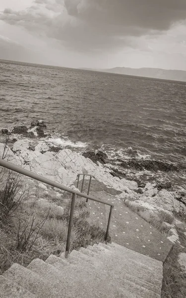 Novi Vinodolski Hırvatistan 'daki cennet turkuaz plajına ve gezinti güvertesine merdivenler.