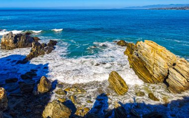 Beautiful rocks cliffs stones and boulders and huge big surfer waves on the beach in La Punta Zicatela Puerto Escondido Oaxaca Mexico.