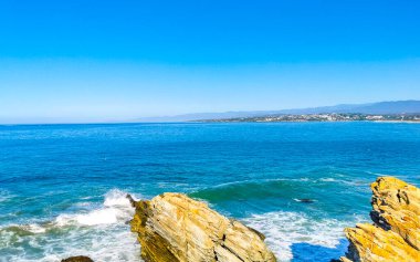 Beautiful rocks cliffs stones and boulders and huge big surfer waves on the beach in La Punta Zicatela Puerto Escondido Oaxaca Mexico.
