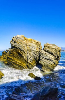 Beautiful rocks cliffs stones and boulders and huge big surfer waves on the beach in La Punta Zicatela Puerto Escondido Oaxaca Mexico.