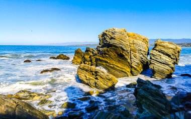 Beautiful rocks cliffs stones and boulders and huge big surfer waves on the beach in La Punta Zicatela Puerto Escondido Oaxaca Mexico.