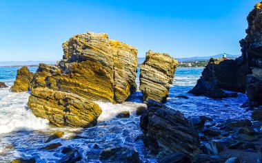 Beautiful rocks cliffs stones and boulders and huge big surfer waves on the beach in La Punta Zicatela Puerto Escondido Oaxaca Mexico.