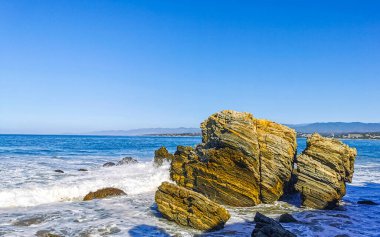 Beautiful rocks cliffs stones and boulders and huge big surfer waves on the beach in La Punta Zicatela Puerto Escondido Oaxaca Mexico.