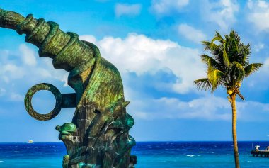The ancient architecture of the Portal Maya in the Fundadores park with blue sky and turquoise seascape and beach panorama in Playa del Carmen Quintana Roo Mexico.