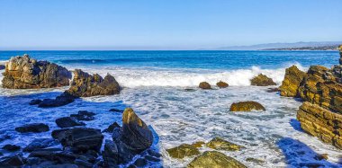 Beautiful rocks cliffs stones and boulders and huge big surfer waves on the beach in La Punta Zicatela Puerto Escondido Oaxaca Mexico.