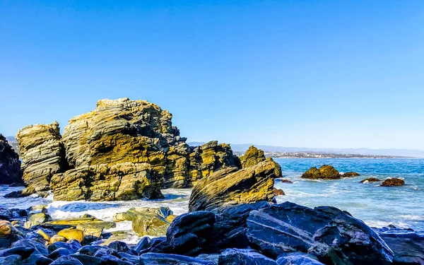 Beautiful rocks cliffs stones and boulders and huge big surfer waves on the beach in La Punta Zicatela Puerto Escondido Oaxaca Mexico.