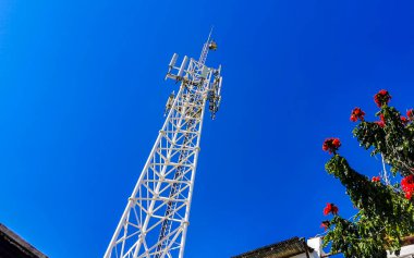 Mavi arka plan radyasyonlu kırmızı beyaz 5G kulesi Zicatela Puerto Escondido Oaxaca Meksika 'da bizi öldürüyor..