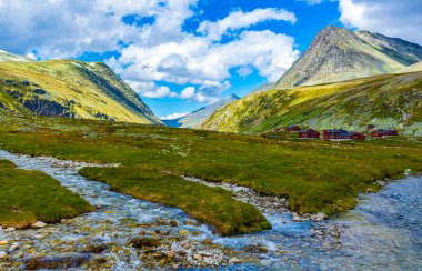 Beautiful mountain and landscape panorama with untouched nature rivers lakes rocks stones and red huts houses in Rondane National Park Ringbu Innlandet Norway in Scandinavia. clipart