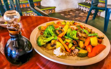 Zicatela Puerto Meksika 'daki El Cafecito' da beyaz tabakta kızarmış pirinç ve sebze..