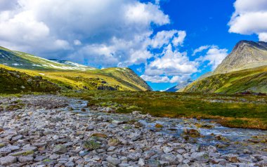 Ellenmemiş doğa nehirleri, kayalar, kayalar ve İskandinavya 'daki Rondane Ulusal Parkı Ringbu Innlandet Norveç' teki kırmızı kulübelerden oluşan güzel dağ ve manzara manzarası..