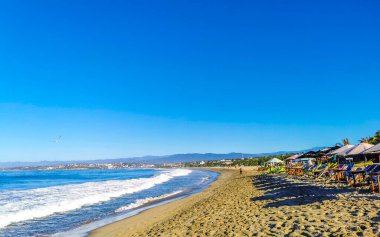 Puerto Escondido Oaxaca Meksika 27. Ocak 2023 Parasols Şemsiyeleri, La Punta Zicatela Puerto Escondido Oaxaca Meksika 'daki tropikal Meksika plajında insanları kaya ve dalgalara boğar..