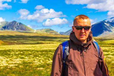 Genç yürüyüşçü ve güzel yaz manzarası dağları, nehir kayaları ve İskandinavya 'daki Ringbu Innlandet Norveç' teki Rondane Ulusal Parkı 'nın yürüyüş yolu..