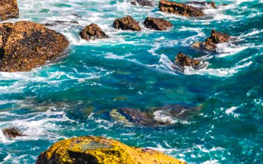 Beautiful rocks cliffs stones and boulders and huge big surfer waves and natural panorama view on the beach in Bacocho Puerto Escondido Oaxaca Mexico.