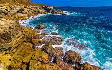 Beautiful rocks cliffs stones and boulders and huge big surfer waves and natural panorama view on the beach in Bacocho Puerto Escondido Oaxaca Mexico.