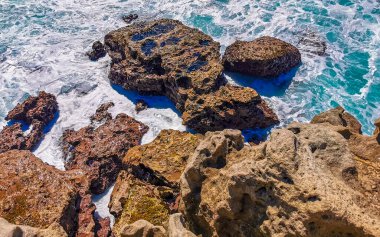 Beautiful rocks cliffs stones and boulders and huge big surfer waves and natural panorama view on the beach in Bacocho Puerto Escondido Oaxaca Mexico.