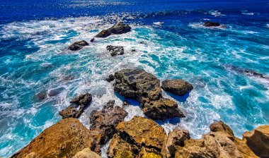 Beautiful rocks cliffs stones and boulders and huge big surfer waves and natural panorama view on the beach in Bacocho Puerto Escondido Oaxaca Mexico.