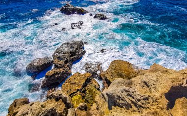 Beautiful rocks cliffs stones and boulders and huge big surfer waves and natural panorama view on the beach in Bacocho Puerto Escondido Oaxaca Mexico.