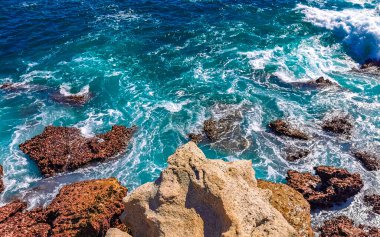 Beautiful rocks cliffs stones and boulders and huge big surfer waves and natural panorama view on the beach in Bacocho Puerto Escondido Oaxaca Mexico.