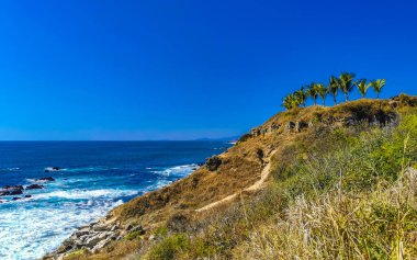 Beautiful rocks cliffs stones and boulders and huge big surfer waves and natural panorama view on the beach in Bacocho Puerto Escondido Oaxaca Mexico.