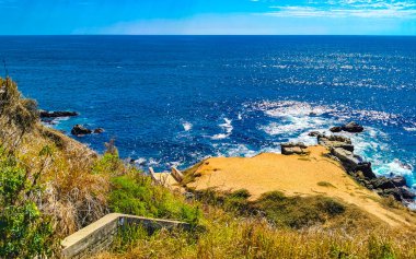 Beautiful rocks cliffs stones and boulders and huge big surfer waves and natural panorama view on the beach in Bacocho Puerto Escondido Oaxaca Mexico.