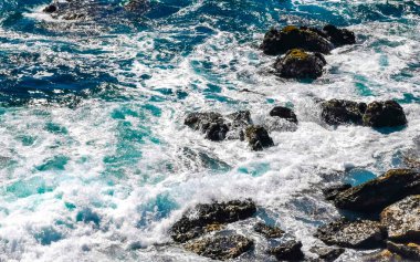 Beautiful rocks cliffs stones and boulders and huge big surfer waves and natural panorama view on the beach in Bacocho Puerto Escondido Oaxaca Mexico.